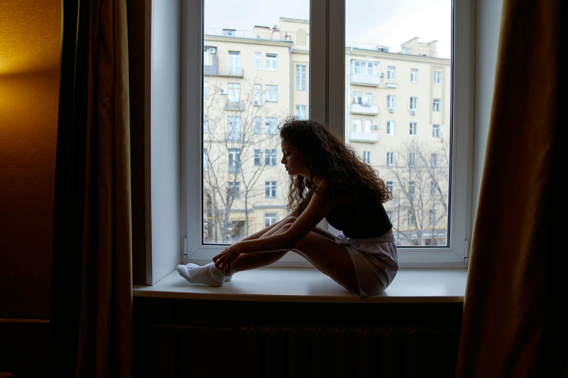 a woman sitting alone by the glass window